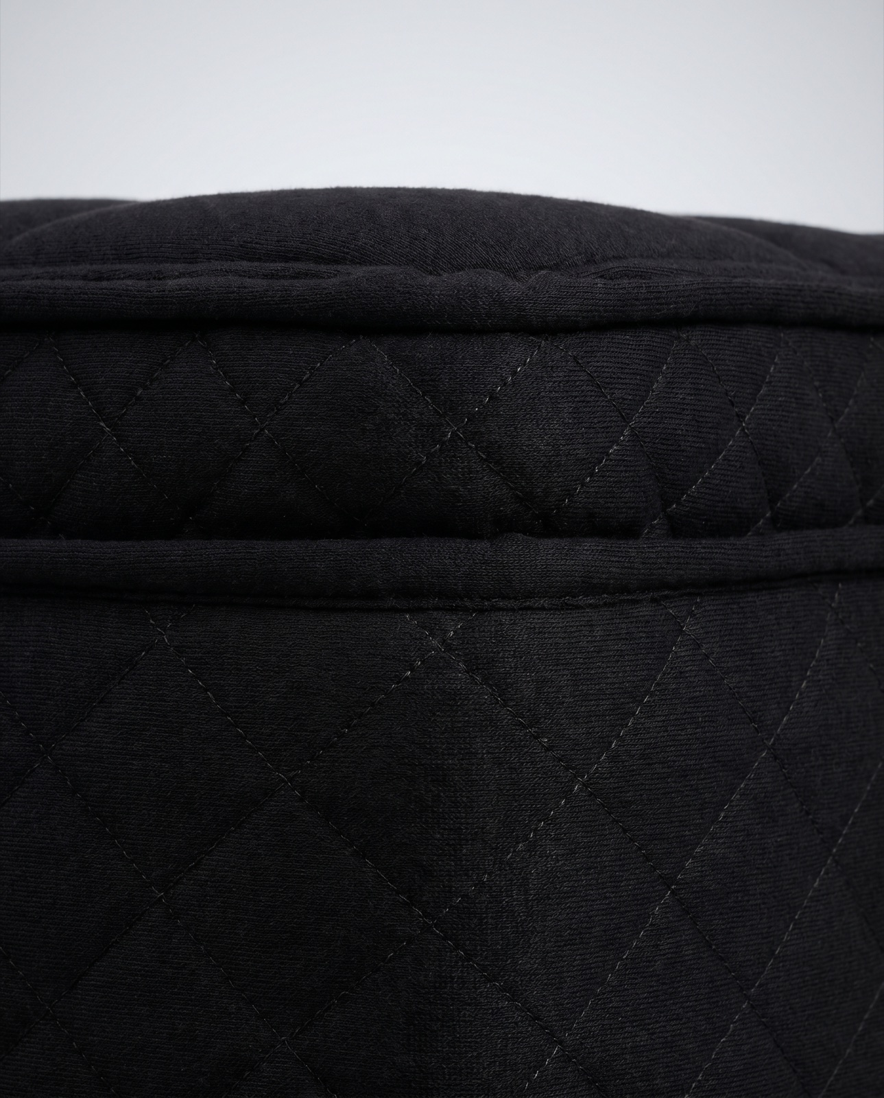 Macro view of the black quilted knit cover with fine diamond stitching