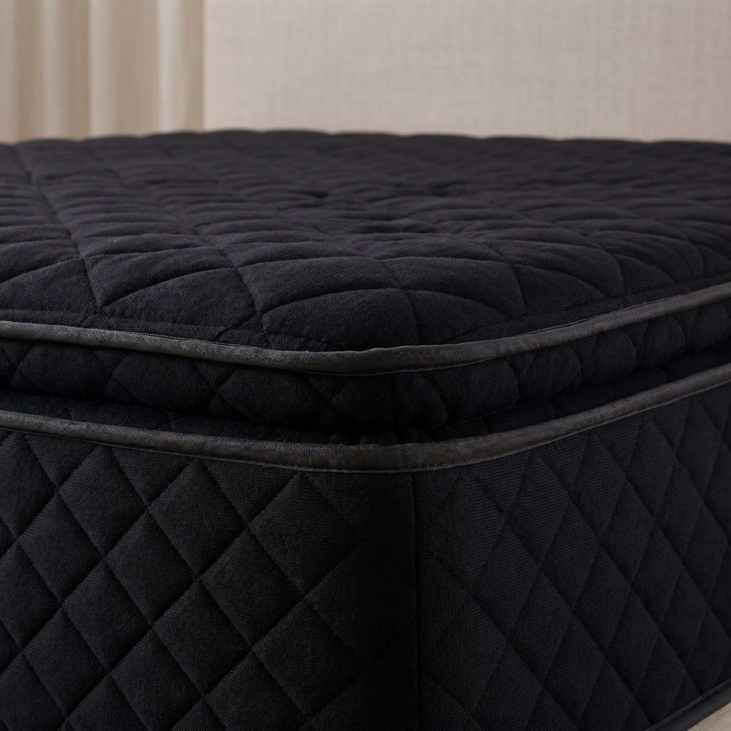 Close-up of the black diamond-quilted knit fabric and stitched eurotop edge
